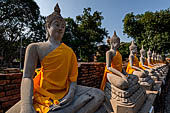 Ayutthaya, Thailand. Wat Yai Chai Mongkhon, saffron-draped Buddha statues inside the temple compound. 